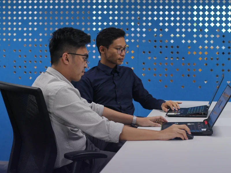 Software developers working on laptops at an Islamabad IT company that uses SEO to win clients