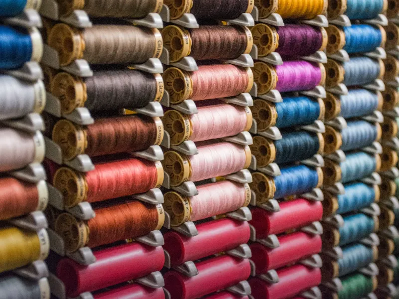 Spools of coloured thread at a Faisalabad textile mill representing SEO for garment exporters